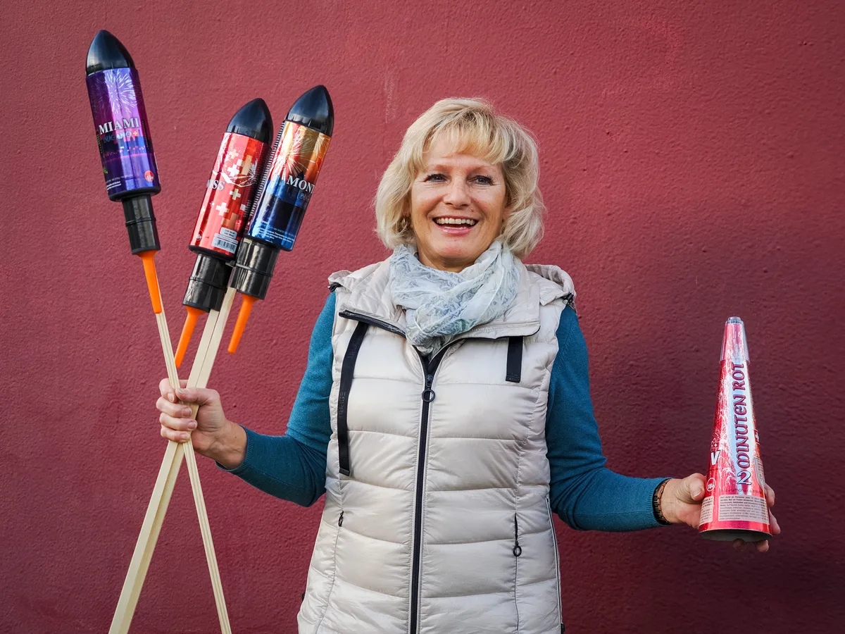 Renate Keller hält Knallkörper in der Hand und lächelt fröhlich.